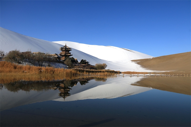 鳴沙山月牙泉景區(qū)雪景。敦煌市委宣傳部供圖，張曉亮攝