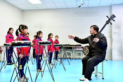 圖為12月30日，在惠民縣胡集鎮(zhèn)第一小學(xué)，老師指導(dǎo)學(xué)生學(xué)習(xí)西河大鼓。新華社記者 郭緒雷攝