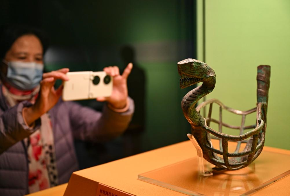 1月14日，觀眾在上海博物館蛇年迎春展拍攝展品蛇綱網(wǎng)狀銅器。新華社發(fā)（陳浩明攝）