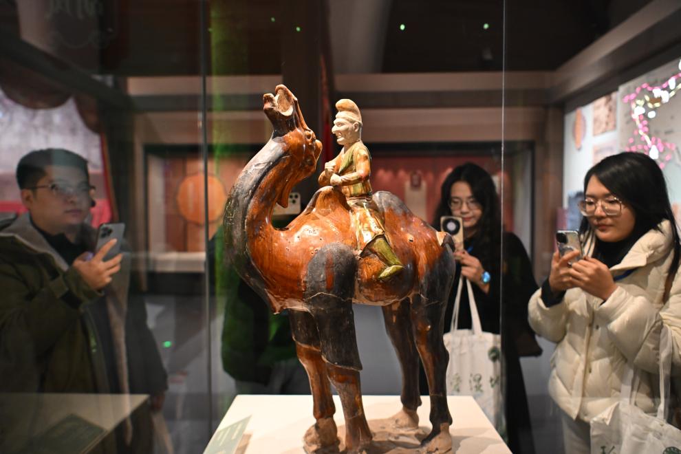 1月15日，觀眾在拍攝“長(zhǎng)安三萬(wàn)里——陜西唐代文物精華展”展出的三彩胡人騎駝俑。（新華社記者 孫凡越 攝）
