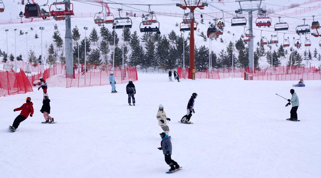 2025年1月8日，滑雪愛(ài)好者在新疆阿勒泰市將軍山滑雪場(chǎng)的雪道上滑行。新華社記者 張嘯誠(chéng) 攝