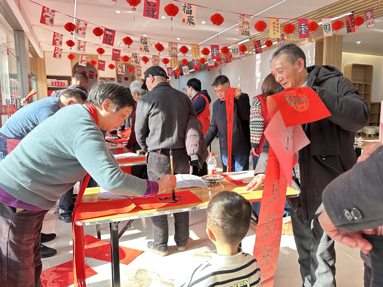 今年春節(jié)前夕，慶元縣濛洲街道同濟新村，一場送春聯(lián)活動熱鬧舉行。慶元縣融媒體中心 供圖