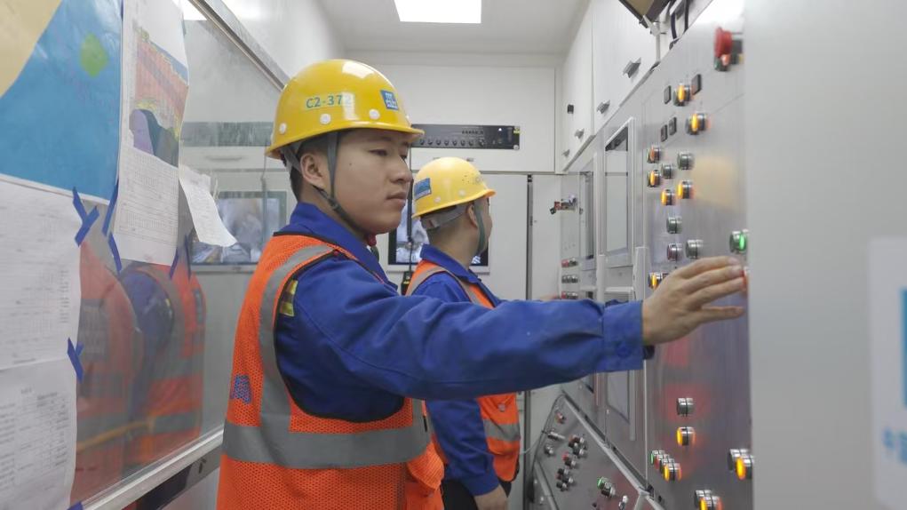 盾構(gòu)司機何曉波在駕駛室內(nèi)調(diào)試盾構(gòu)機參數(shù)。（劉芬攝）