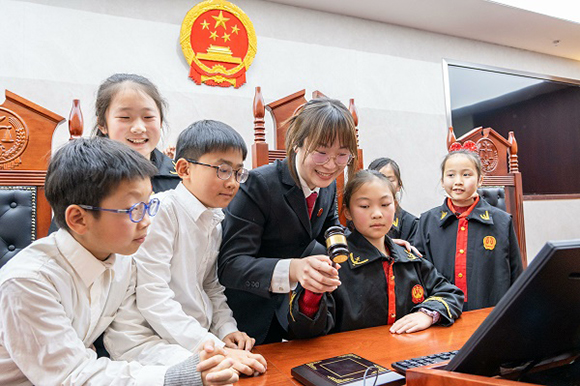 圖①：干警帶同學(xué)們體驗(yàn)敲法槌。