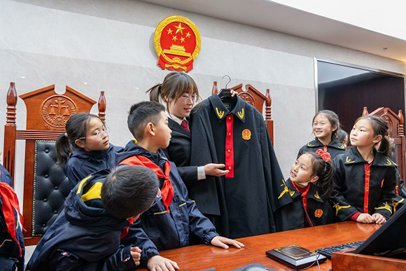 圖②：干警向同學(xué)們介紹法袍。