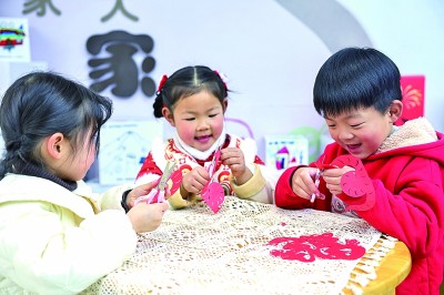 圖為孩子們?cè)诶蠋熤笇?dǎo)下制作蛇年主題剪紙。 新華社記者 徐昱攝