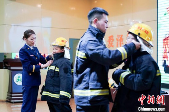 圖為學(xué)生們現(xiàn)場(chǎng)穿戴消防頭盔和戰(zhàn)斗服。中新社記者 趙宇航 攝