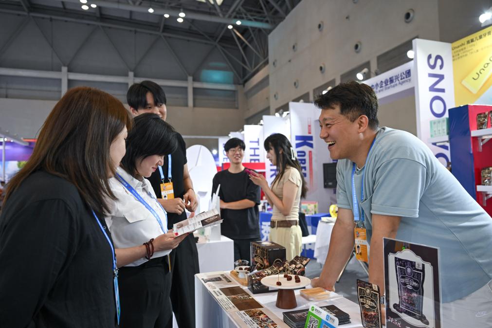 5月22日，韓國(guó)展商（右一）在西洽會(huì)現(xiàn)場(chǎng)向參觀(guān)者介紹產(chǎn)品。新華社記者 陳誠(chéng) 攝